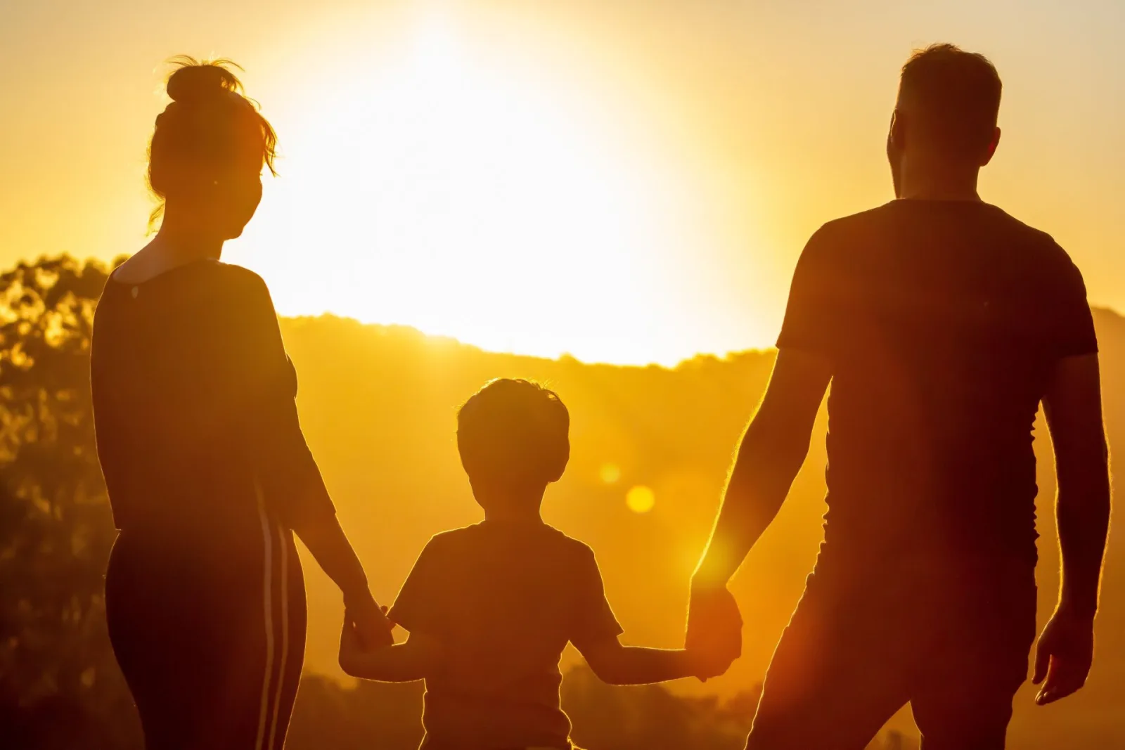 Persona con los brazos abiertos frente a un atardecer